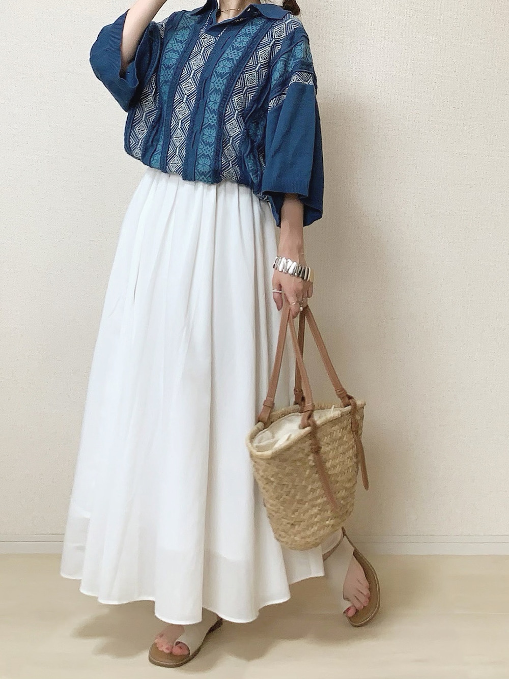 ブルー系のポロシャツを着用したレディースの夏コーディネートの1枚目の写真