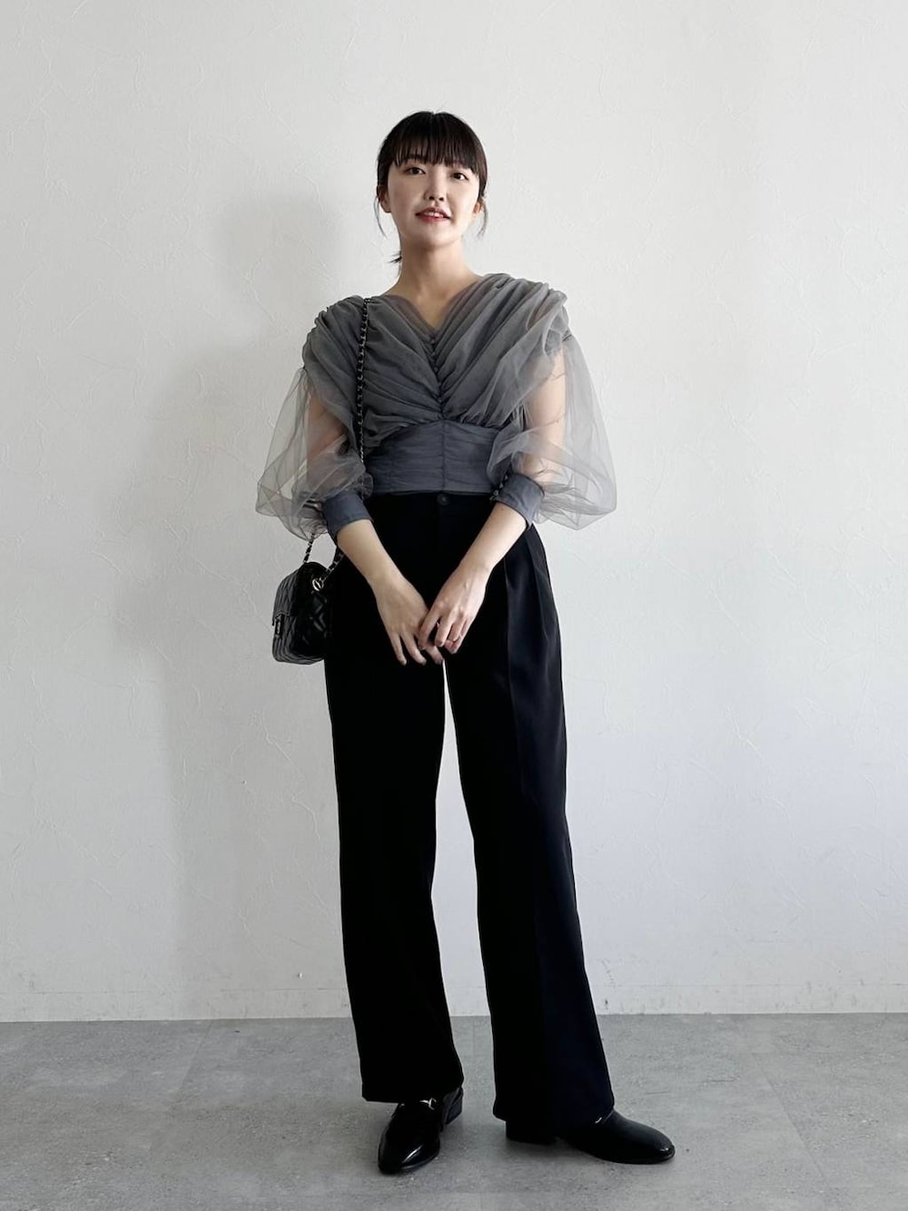 ブラック系のローファー、グレー系のTシャツ/カットソー、ブラック系のショルダーバッグを着用したレディースの春コーディネートの1枚目の写真