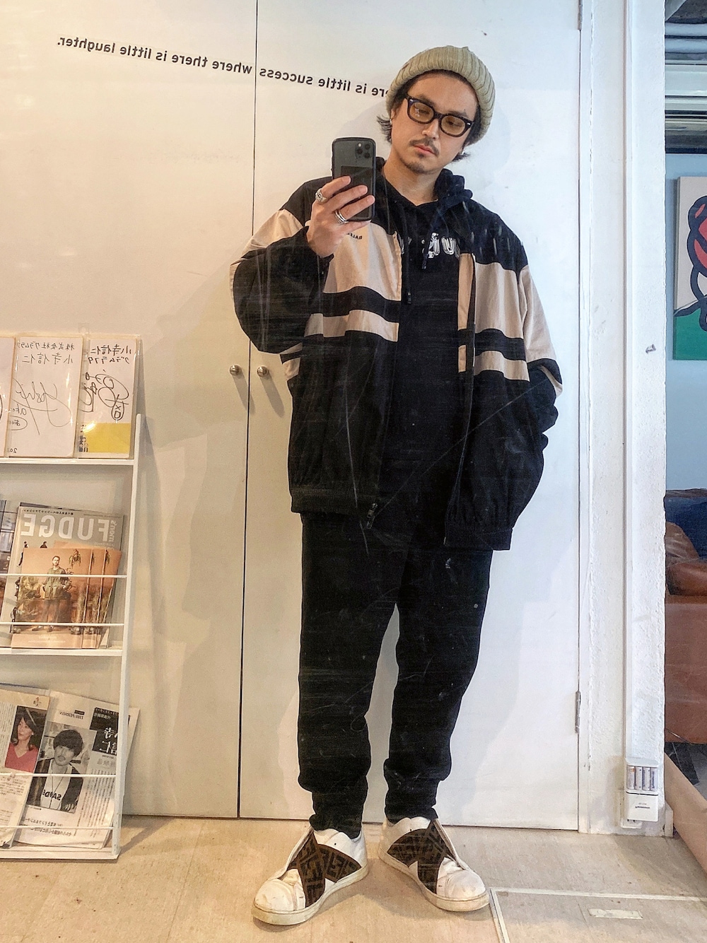 ベージュ系のナイロンジャケット、ブラック系のパーカー、ブラック系のパンツを着用したメンズの春コーディネートの1枚目の写真