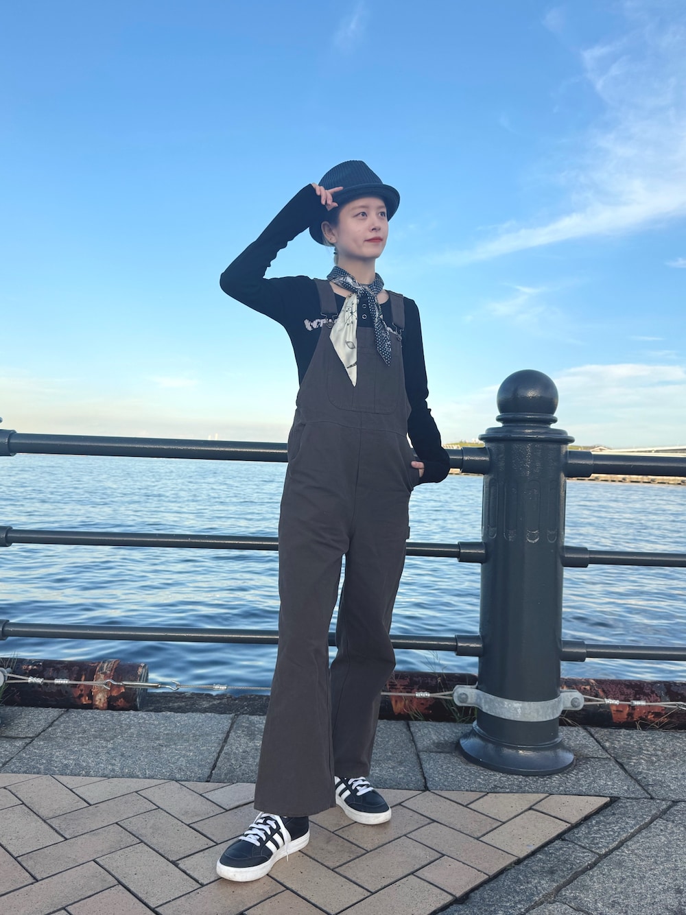 ブルー系のハットを着用したレディースの秋コーディネートの1枚目の写真