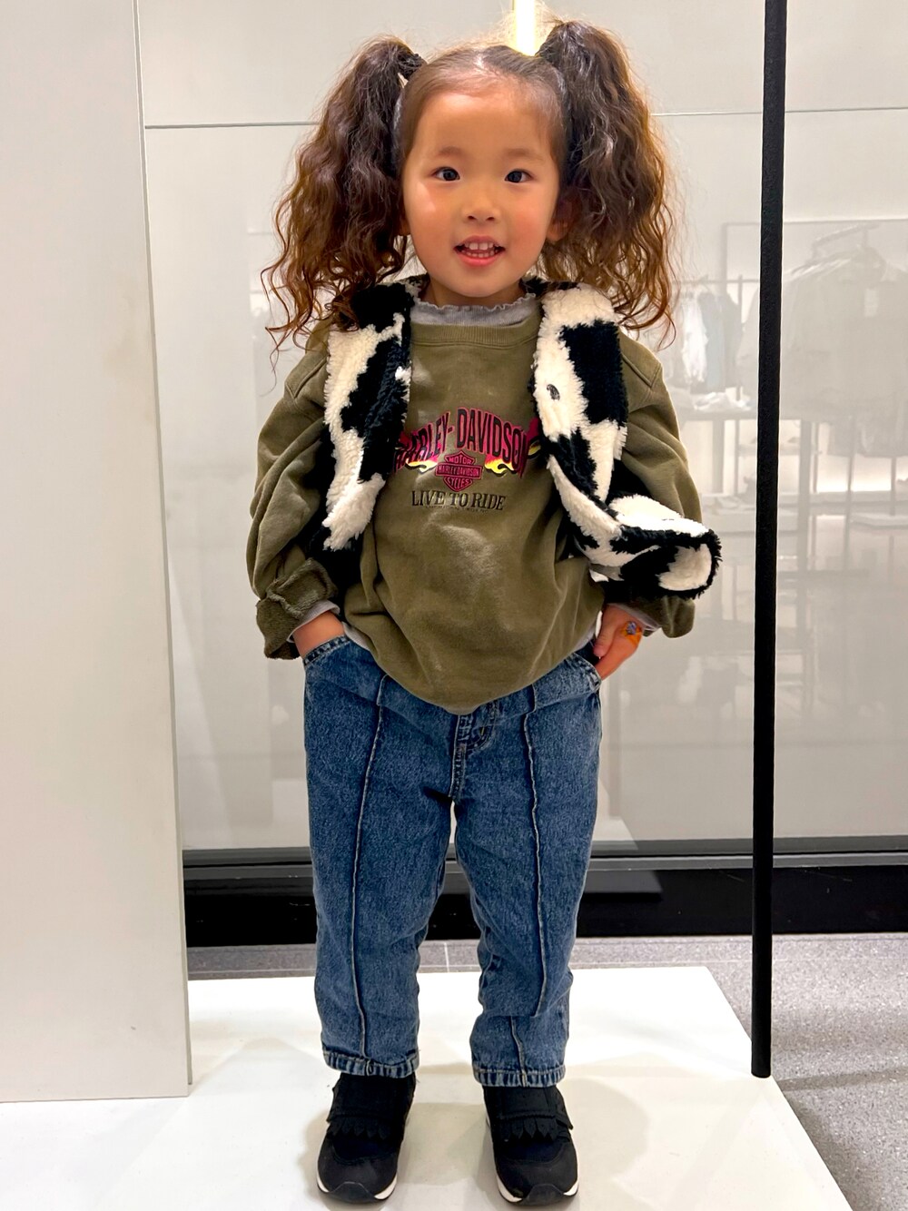 ブラック系のスニーカー、ブルー系のパンツ、グリーン系のトップスを着用したキッズの春コーディネートの1枚目の写真