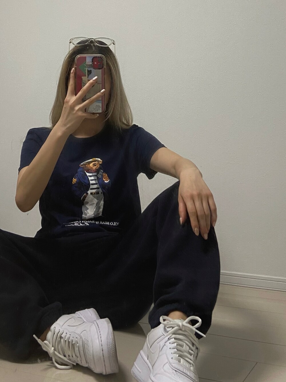 ブラック系のトップス、ブラック系のパンツ、ホワイト系のシューズを着用したレディースの冬コーディネートの1枚目の写真