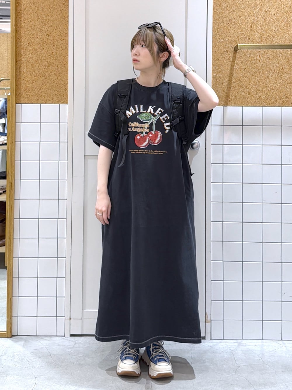 ブラック系のワンピース、レッド系のバックパック/リュック、ブラック系のサングラスを着用したレディースの夏コーディネートの1枚目の写真
