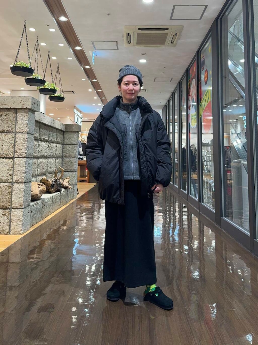 ブラック系のダウンジャケット/コート、ブラック系のスカート、グレー系のブルゾンを着用したレディースの冬コーディネートの1枚目の写真