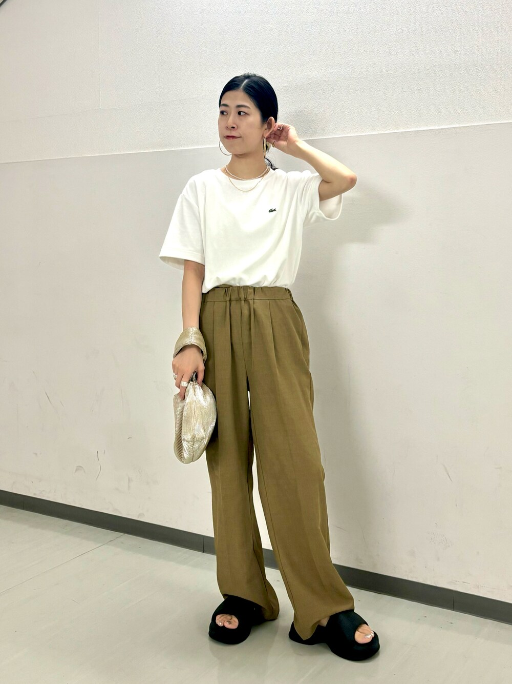 ホワイト系のTシャツ/カットソー、ベージュ系のその他パンツ、ゴールド系のハンドバッグを着用したレディースの夏コーディネートの1枚目の写真