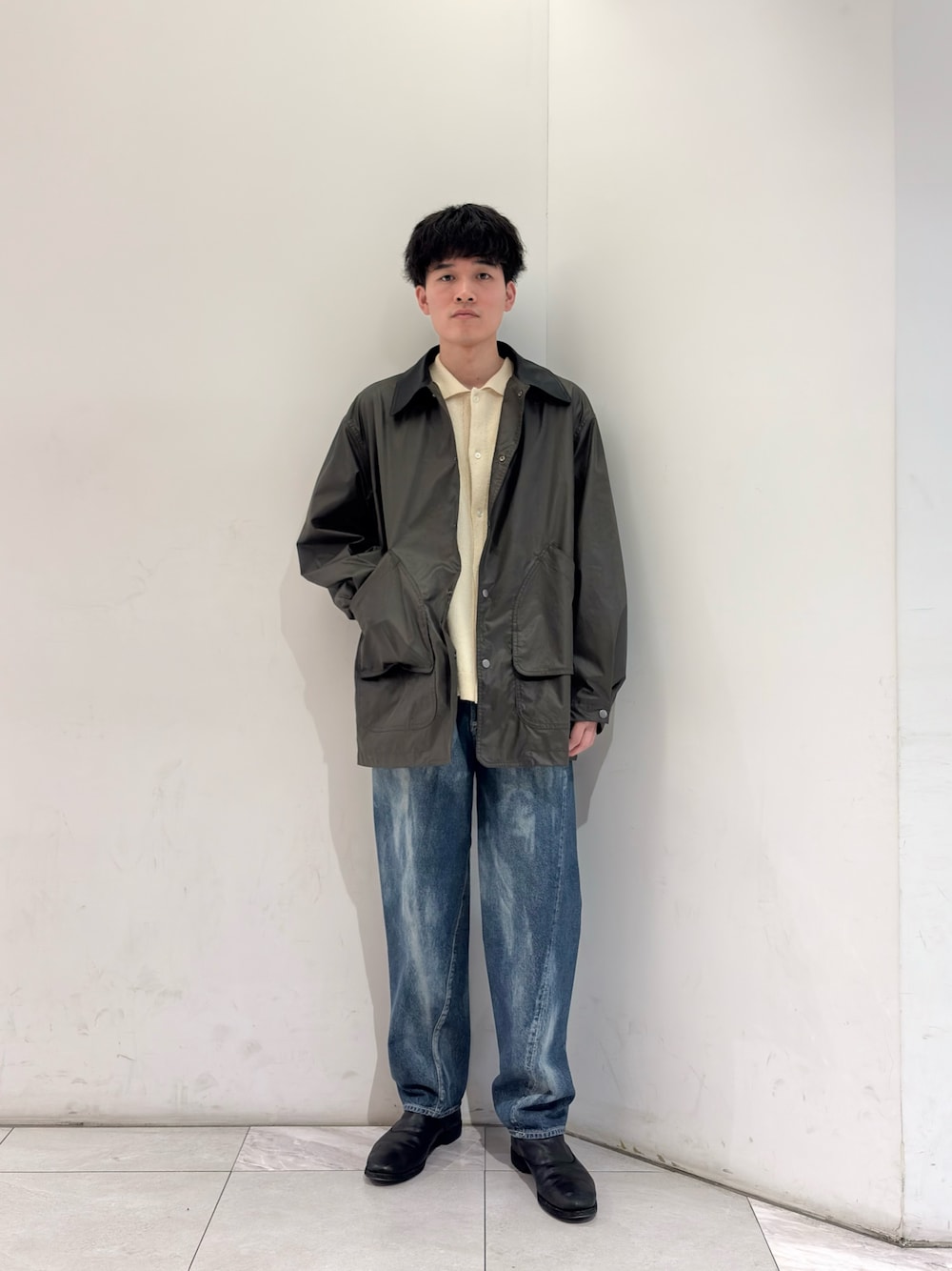 グリーン系のその他アウター、イエロー系のニット/セーター、ブルー系のデニムパンツを着用したメンズの春コーディネートの1枚目の写真