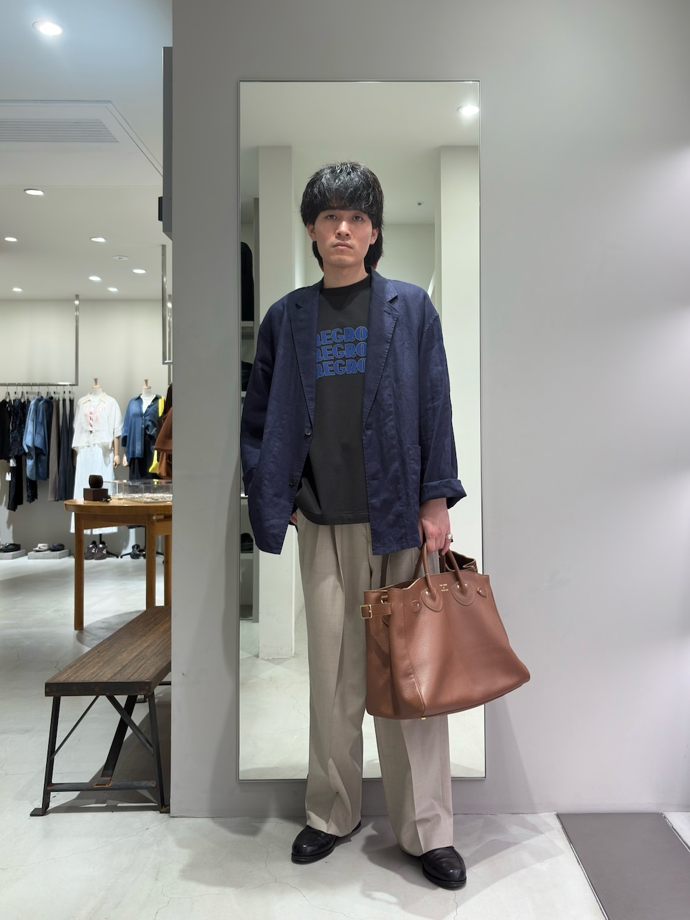 ブルー系のその他アウター、ベージュ系のその他パンツ、ブラウン系のトートバッグを着用したメンズの春コーディネートの1枚目の写真