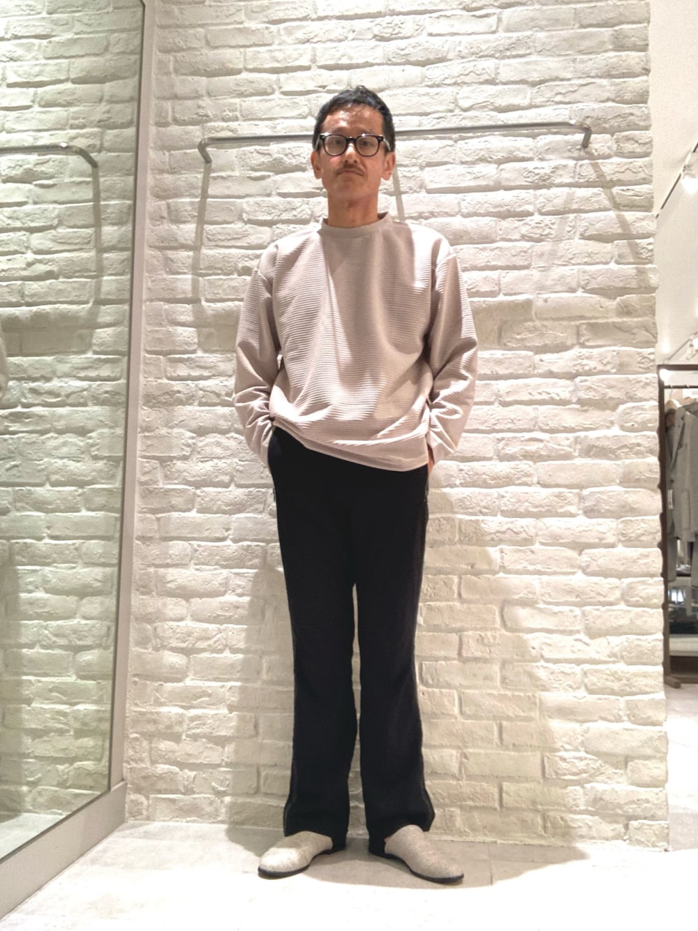 ベージュ系のTシャツ/カットソー、ベージュ系のスリッポンを着用したメンズの秋コーディネートの1枚目の写真