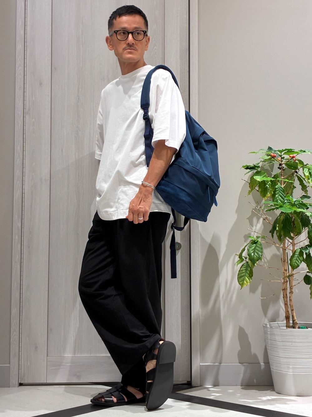 ブルー系のバックパック/リュック、ホワイト系のTシャツ/カットソー、ブラック系のその他パンツを着用したメンズの夏コーディネートの1枚目の写真