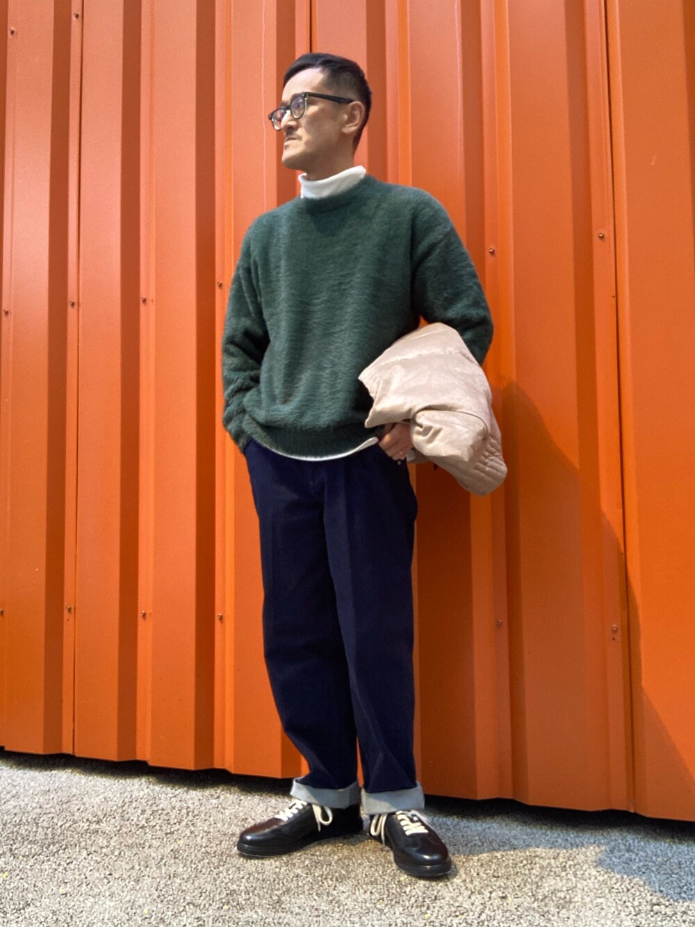 ホワイト系のTシャツ/カットソー、グリーン系のニット/セーター、ブラック系のスニーカーを着用したメンズの冬コーディネートの1枚目の写真