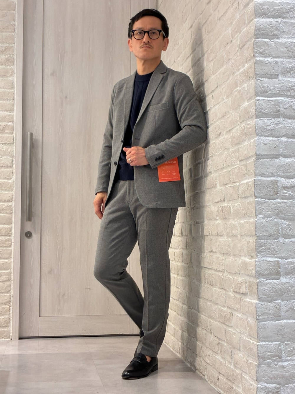 グレー系のセットアップ、グレー系のテーラードジャケット、グレー系のスラックスを着用したメンズの冬コーディネートの1枚目の写真