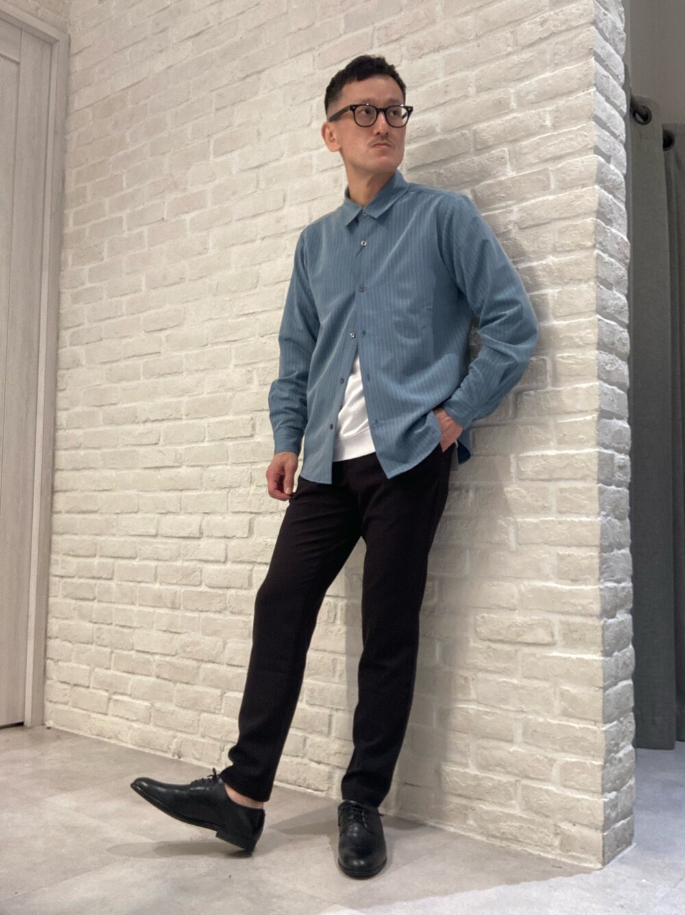 グリーン系のシャツ/ブラウス、ホワイト系のTシャツ/カットソー、ブラック系のスラックスを着用したメンズの春コーディネートの1枚目の写真