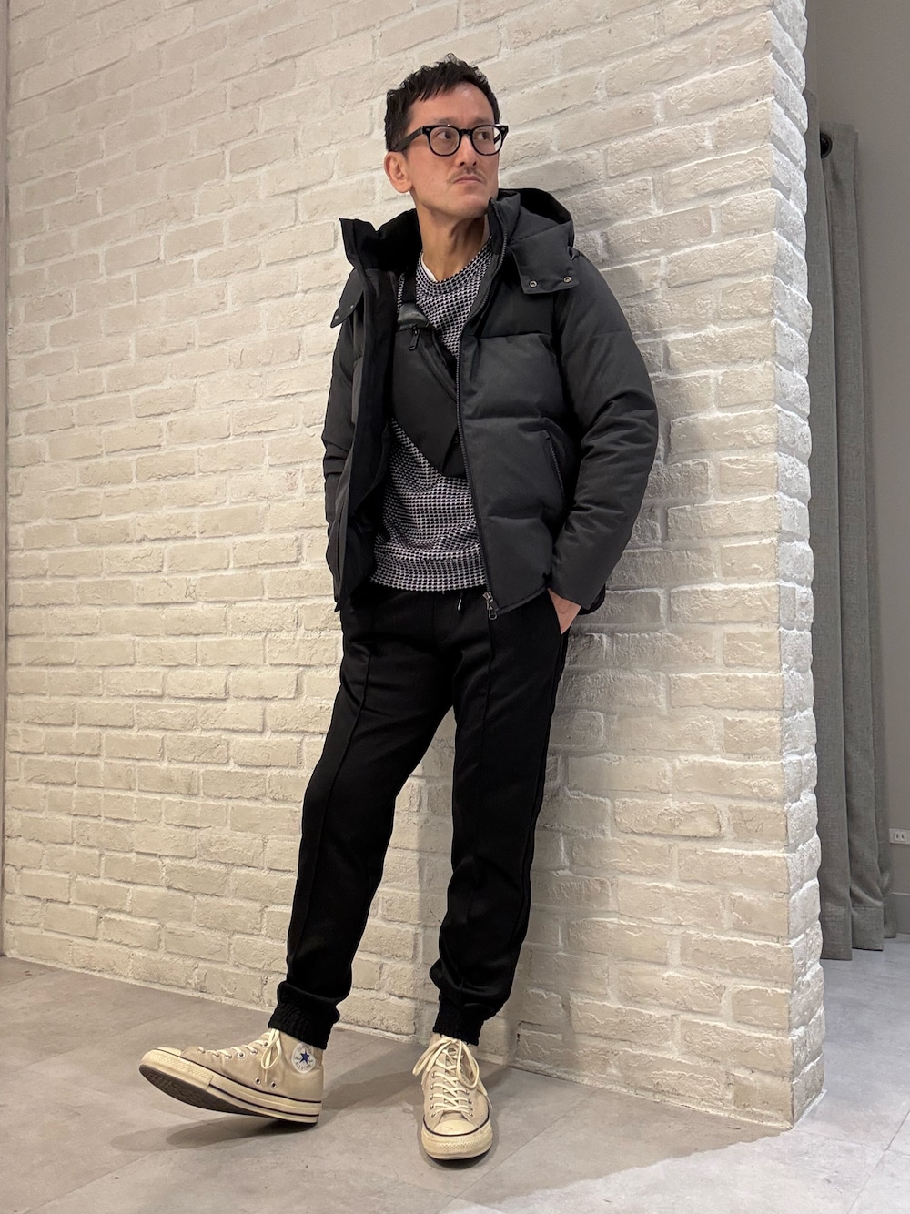 ブラック系のTシャツ/カットソー、グレー系のダウンジャケット/コート、ブラック系のその他パンツを着用したメンズの冬コーディネートの1枚目の写真