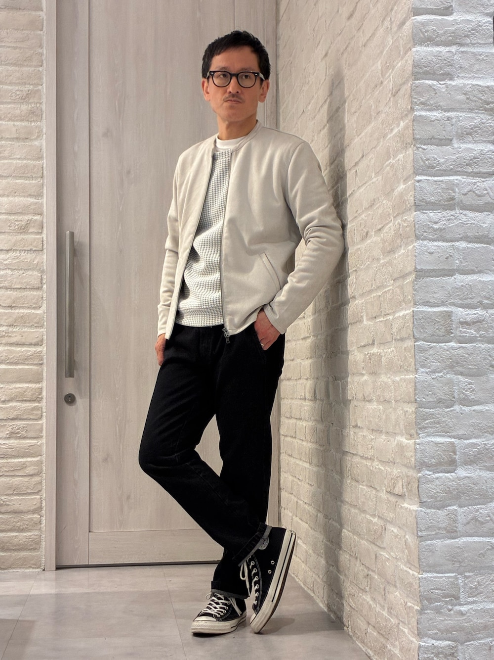 ベージュ系のライダースジャケット、ホワイト系のTシャツ/カットソー、ブラック系のデニムパンツを着用したメンズの春コーディネートの1枚目の写真