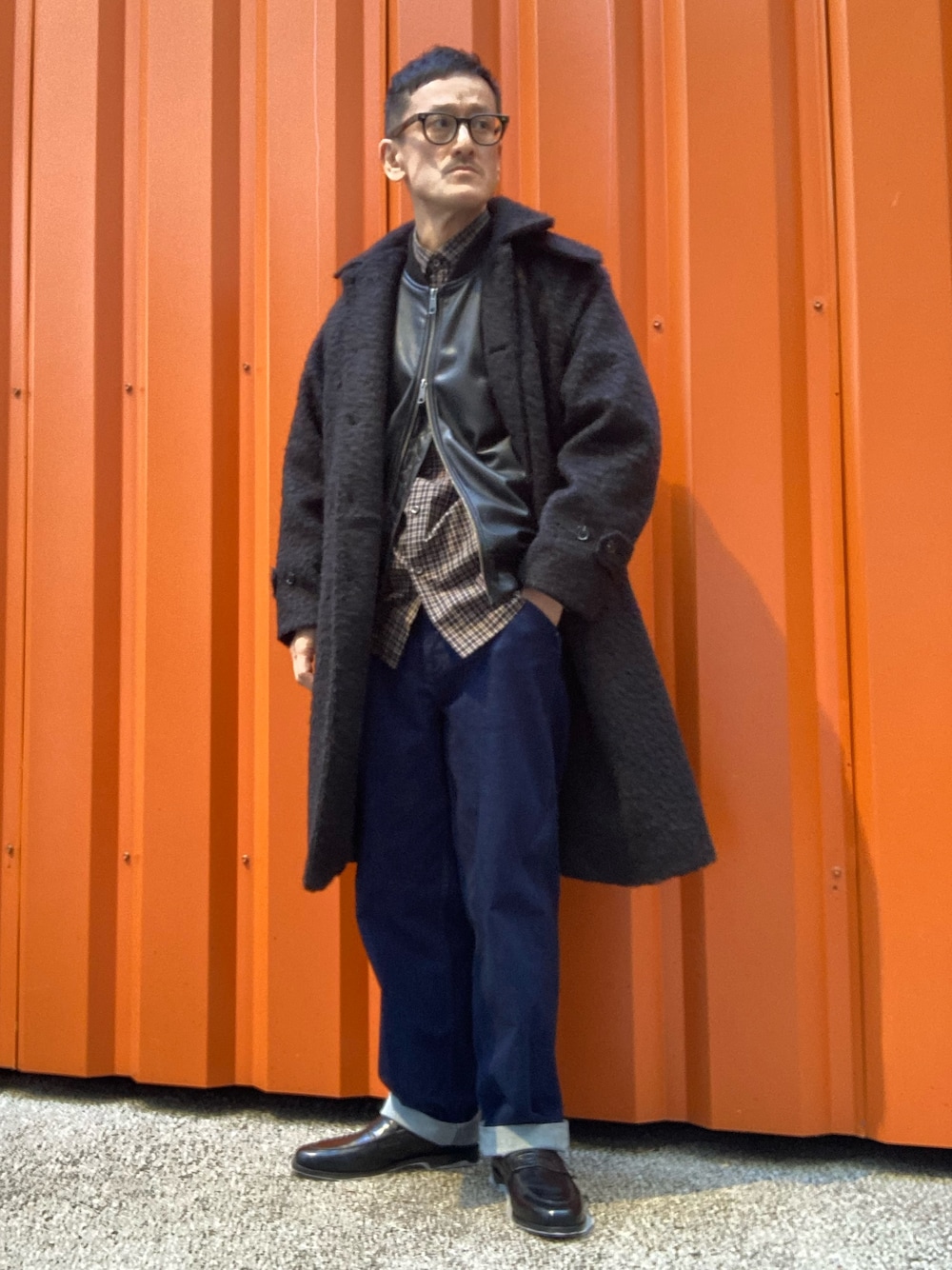 ブラック系のステンカラーコート、ブラック系のライダースジャケット、ブラック系のシャツ/ブラウスを着用したメンズの冬コーディネートの1枚目の写真