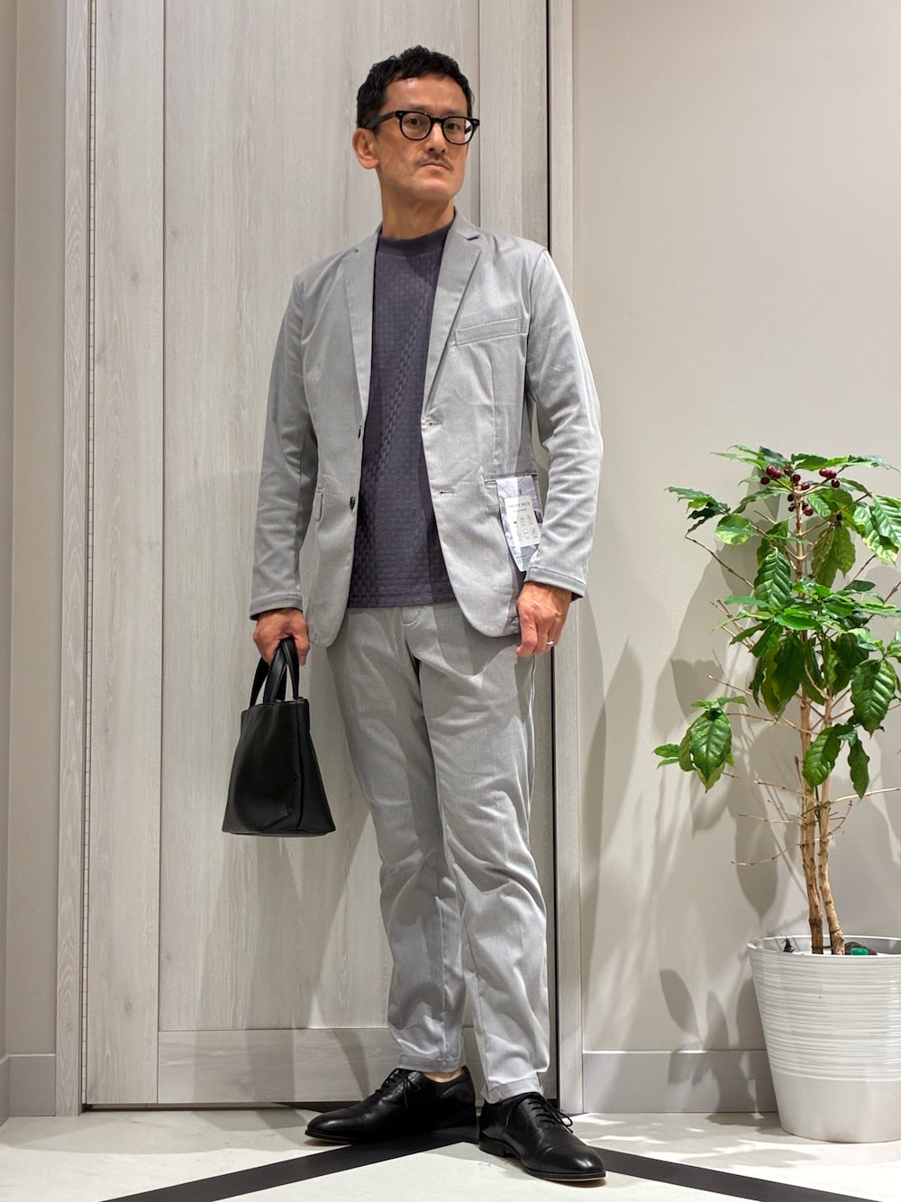 グレー系のセットアップ、グレー系のテーラードジャケット、ブルー系のTシャツ/カットソーを着用したメンズの夏コーディネートの1枚目の写真