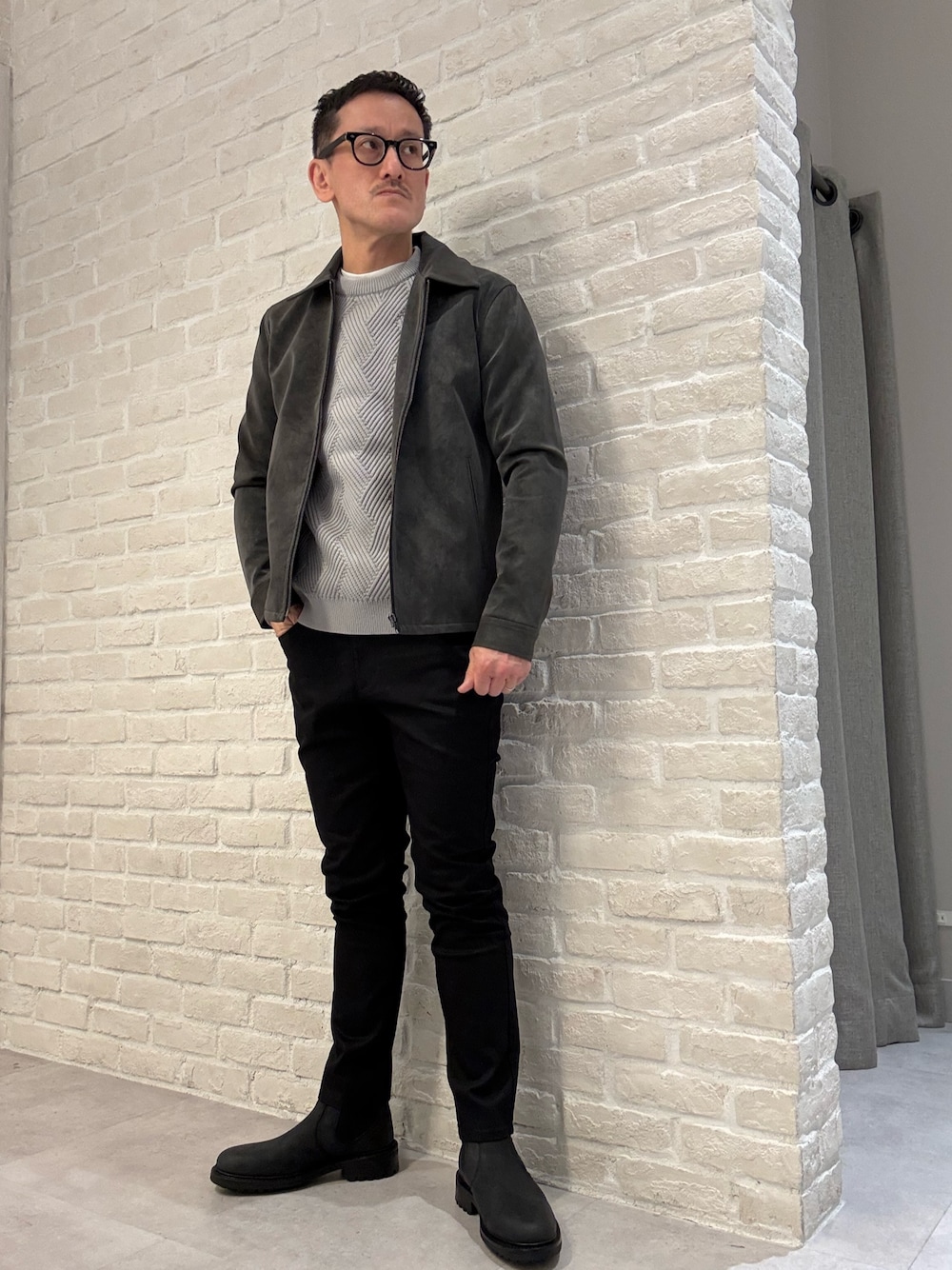 ブラック系のブルゾン、グレー系のニット/セーター、ブラック系のその他パンツを着用したメンズの冬コーディネートの1枚目の写真