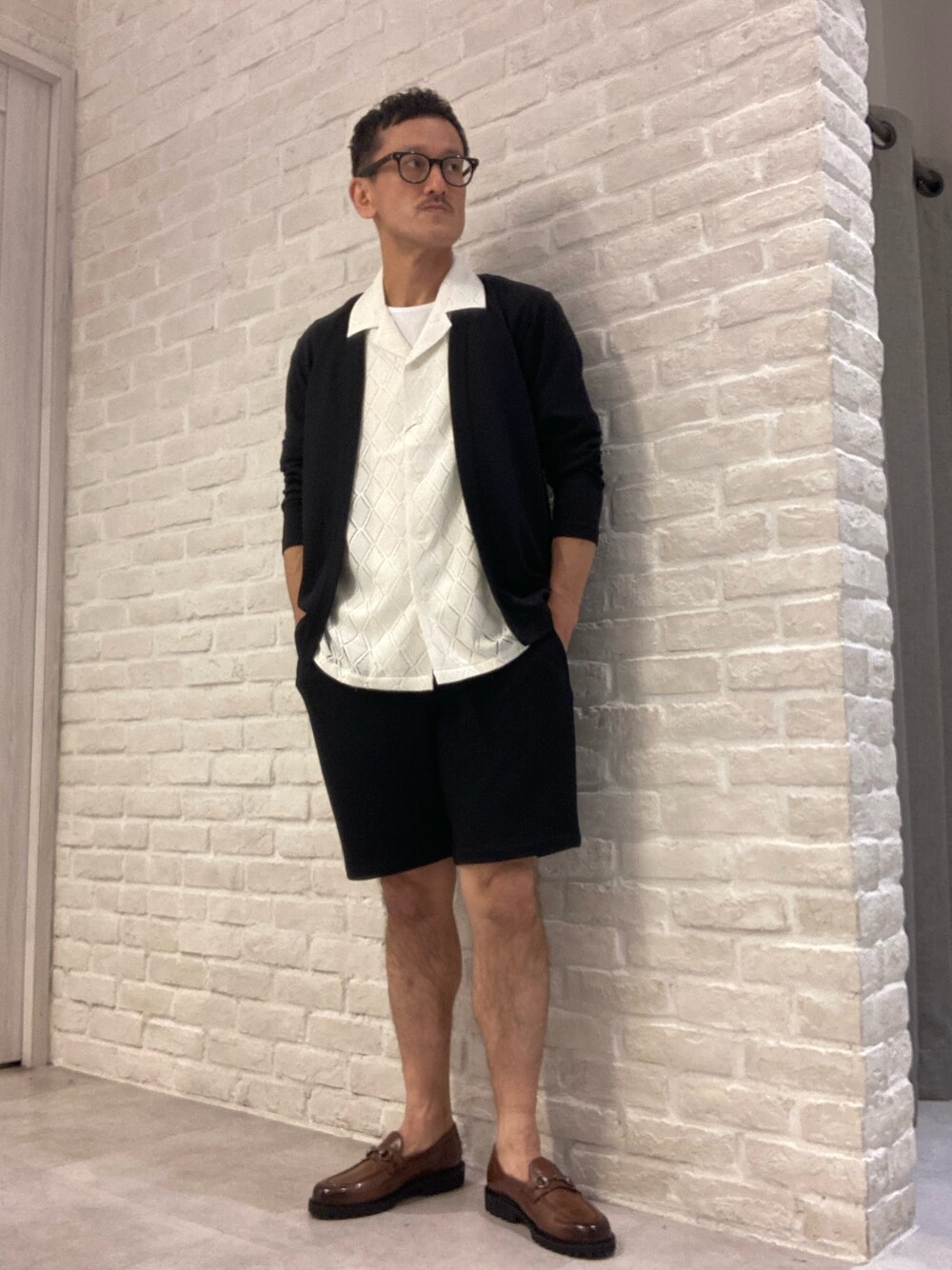 ブラック系のカーディガン/ボレロ、ホワイト系のTシャツ/カットソー、ホワイト系のシャツ/ブラウスを着用したメンズの春コーディネートの1枚目の写真