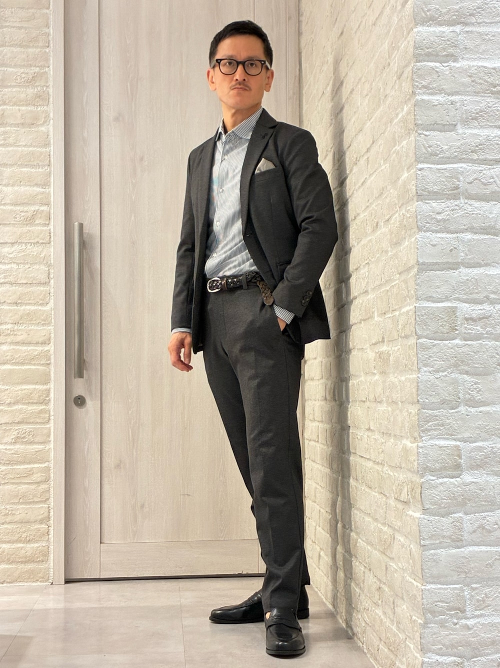 グレー系のテーラードジャケット、グレー系のスラックス、ブルー系のシャツ/ブラウスを着用したメンズの春コーディネートの1枚目の写真