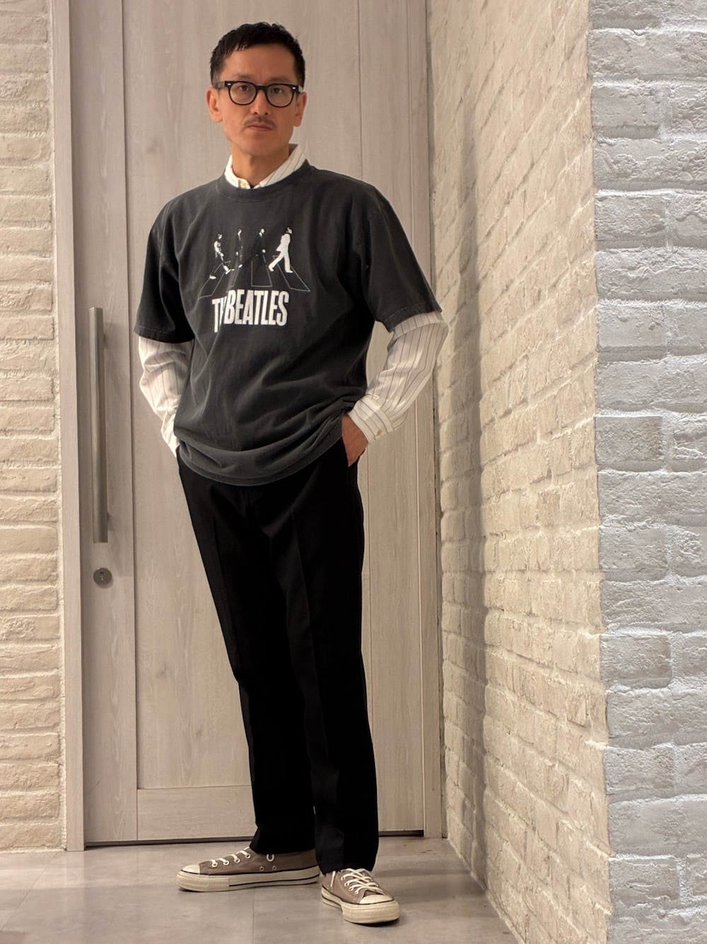 ブラック系のTシャツ/カットソー、ホワイト系のシャツ/ブラウス、ブラック系のスラックスを着用したメンズの春コーディネートの1枚目の写真