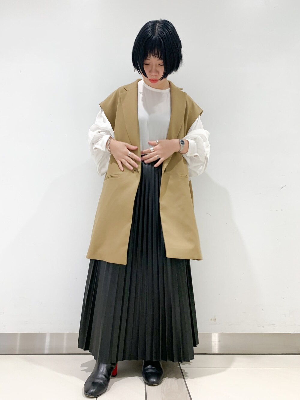 ベージュ系のその他アウター、ブラック系のスカート、ホワイト系のその他を着用したレディースの秋コーディネートの1枚目の写真