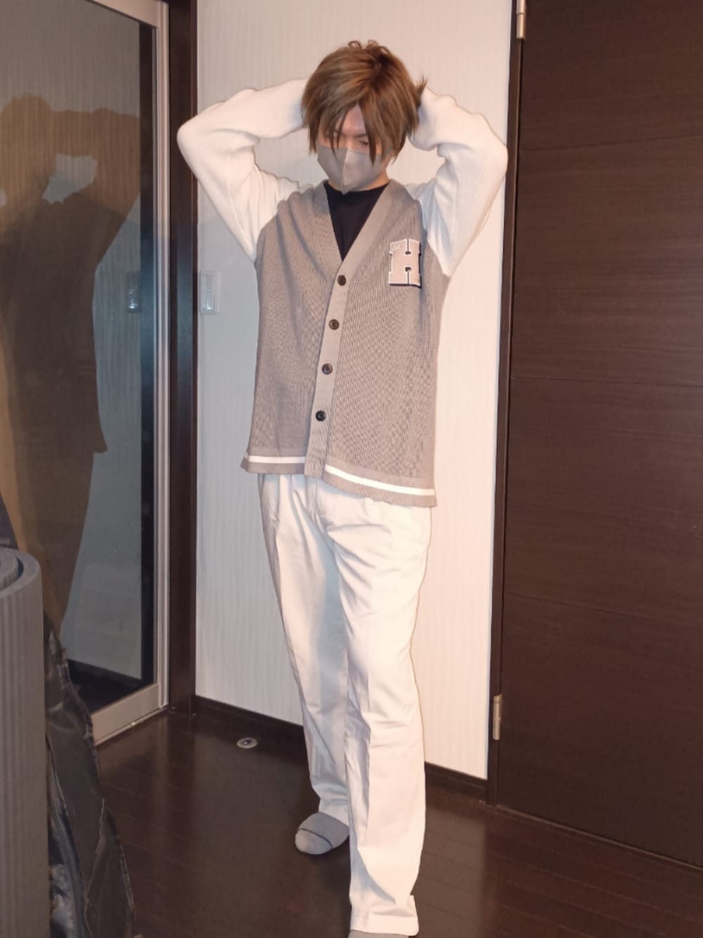 ホワイト系のデニムパンツ、グレー系のニット/セーター、ブラック系のTシャツ/カットソーを着用したメンズの秋コーディネートの1枚目の写真