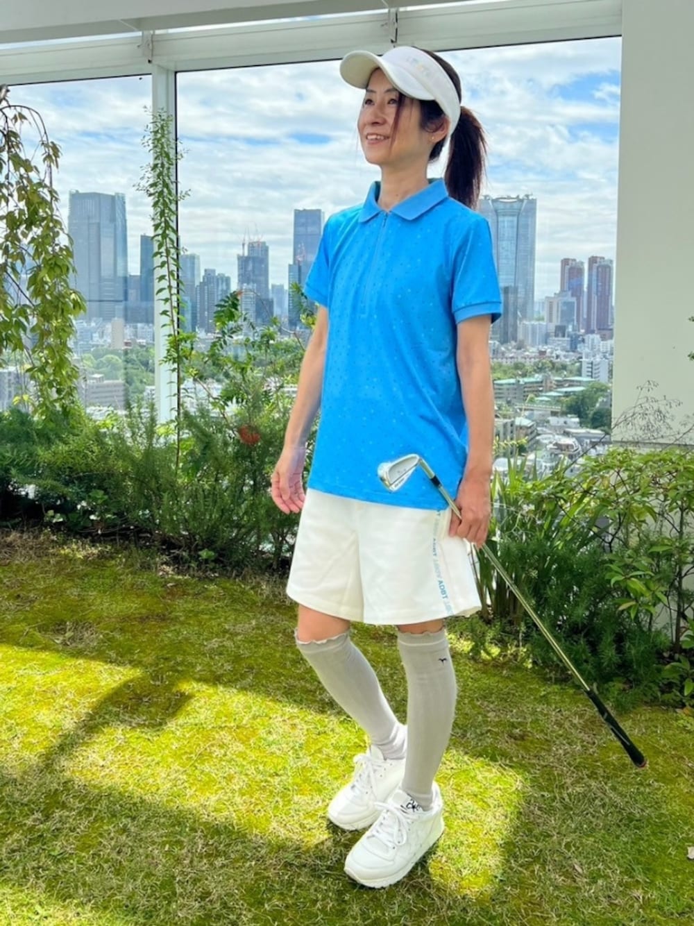 ブルー系のポロシャツ、ホワイト系のその他パンツ、ホワイト系のサンバイザーを着用したレディースの春コーディネートの1枚目の写真