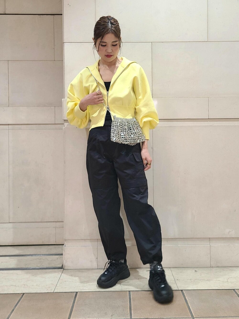 イエロー系のカーディガン/ボレロ、シルバー系のショルダーバッグ、ブラック系のカーゴパンツを着用したレディースの冬コーディネートの1枚目の写真
