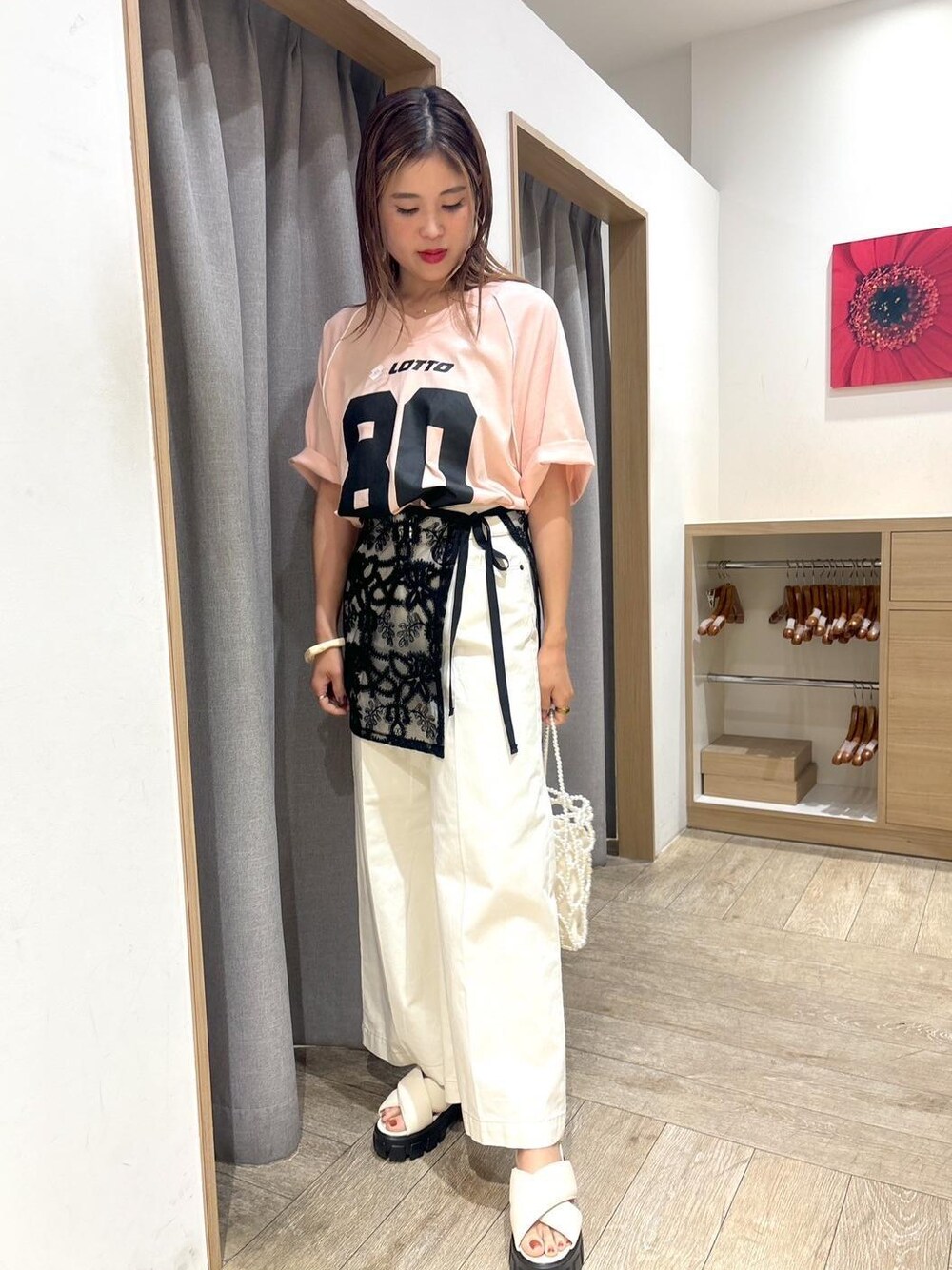 ホワイト系のサンダル、ブラック系のスカート、ホワイト系のデニムパンツを着用したレディースの夏コーディネートの1枚目の写真