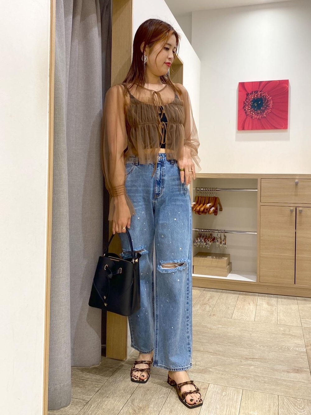 ブラック系のハンドバッグ、ブルー系のデニムパンツ、その他のサンダルを着用したレディースの春コーディネートの1枚目の写真