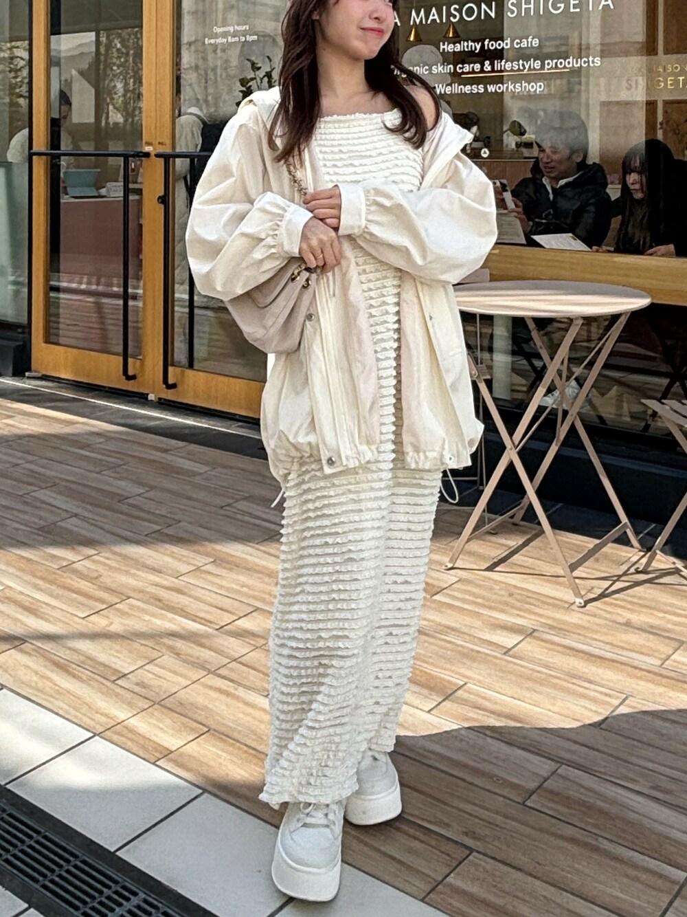 ホワイト系のマウンテンパーカーを着用したレディースの春コーディネートの1枚目の写真