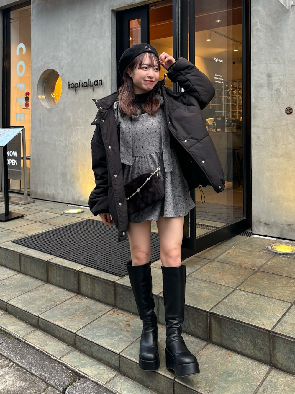 グレー系のキャミソール、ブラック系のダウンジャケット/コート、ブラック系のブーツを着用したレディースの秋コーディネートの1枚目の写真
