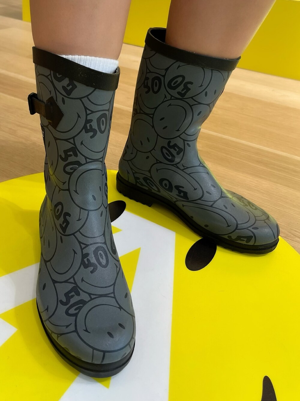 イエロー系のパーカー、グレー系のレインシューズ、ホワイト系のその他パンツを着用したレディースの春コーディネートの5枚目の写真