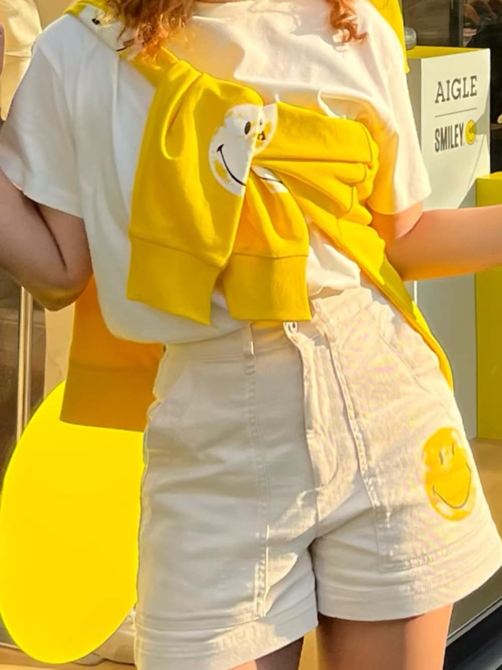 イエロー系のパーカー、グレー系のレインシューズ、ホワイト系のその他パンツを着用したレディースの春コーディネートの4枚目の写真