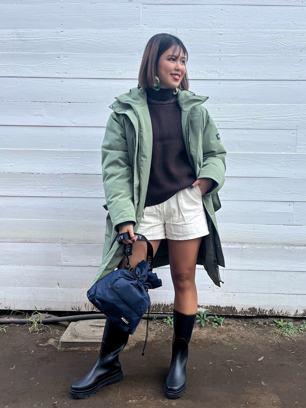 ブラウン系のニット/セーター、グリーン系のダウンジャケット/コートを着用したレディースの秋コーディネートの1枚目の写真