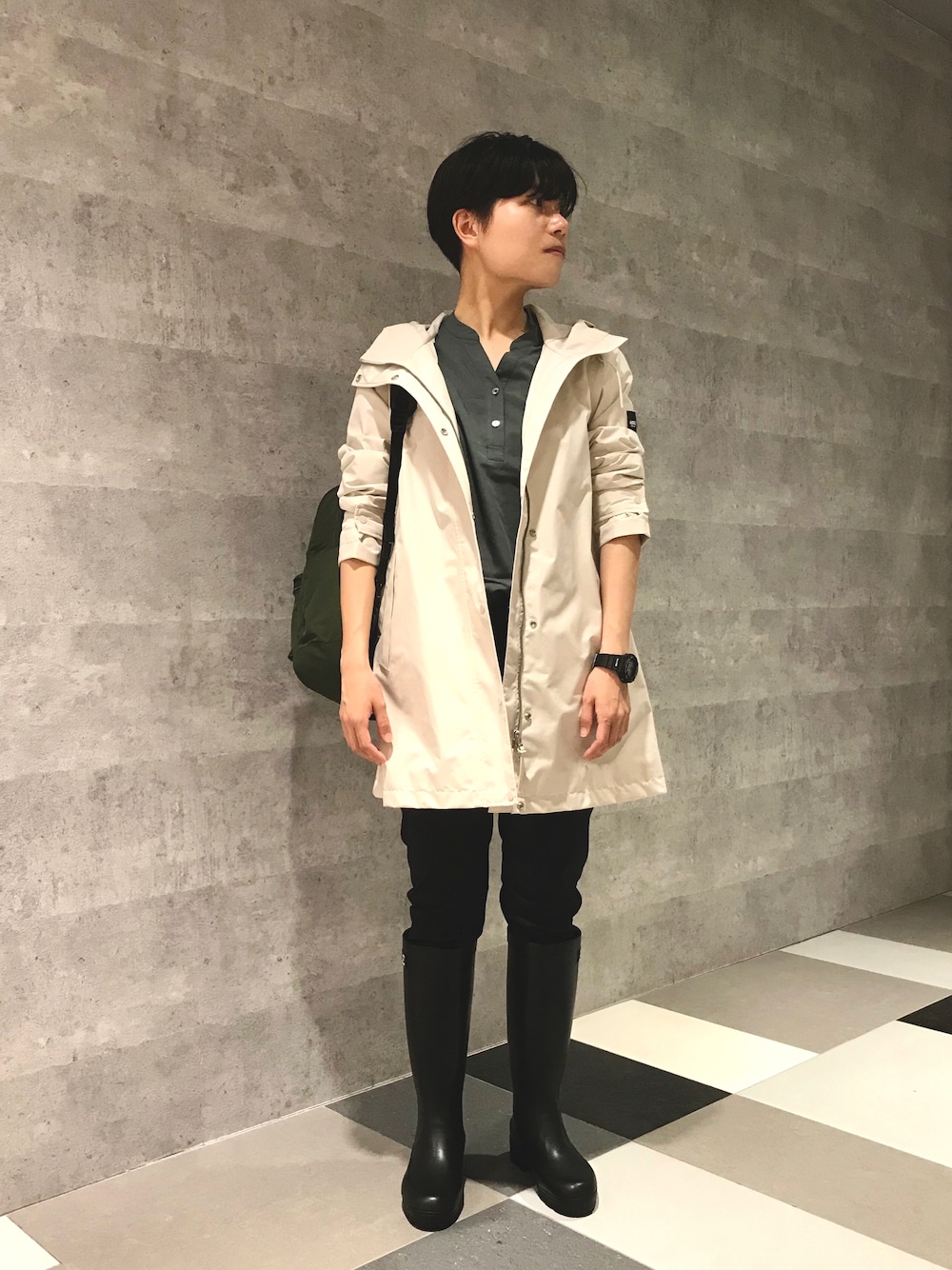 ホワイト系のマウンテンパーカー、グリーン系のバックパック/リュック、ブラック系のブーツを着用したレディースの春コーディネートの1枚目の写真