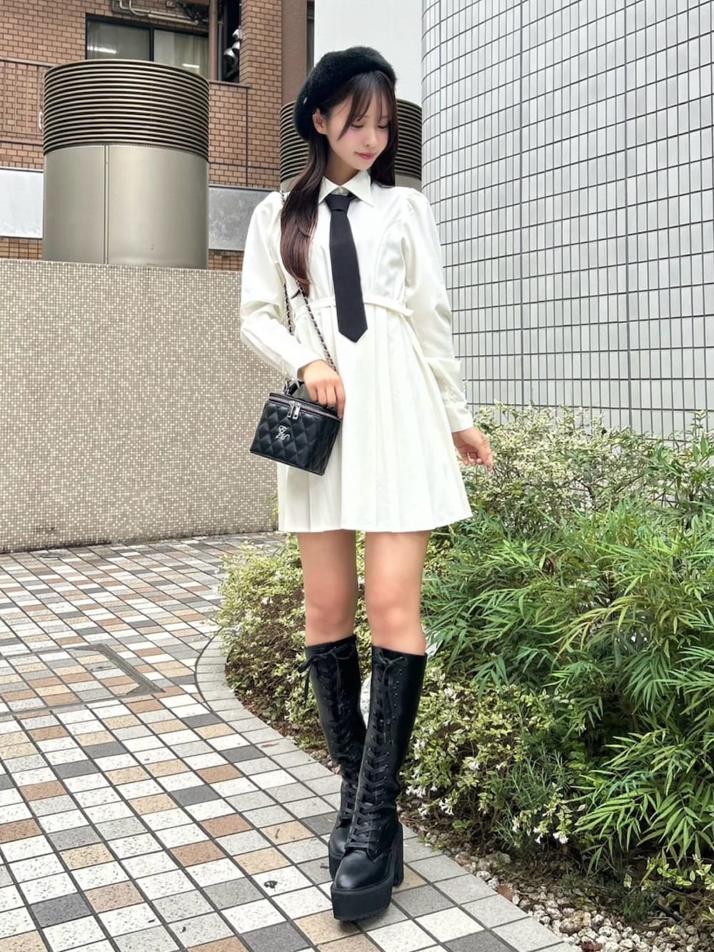 ホワイト系のワンピース、ブラック系のハンドバッグ、ブラック系のブーツを着用したレディースの秋コーディネートの1枚目の写真