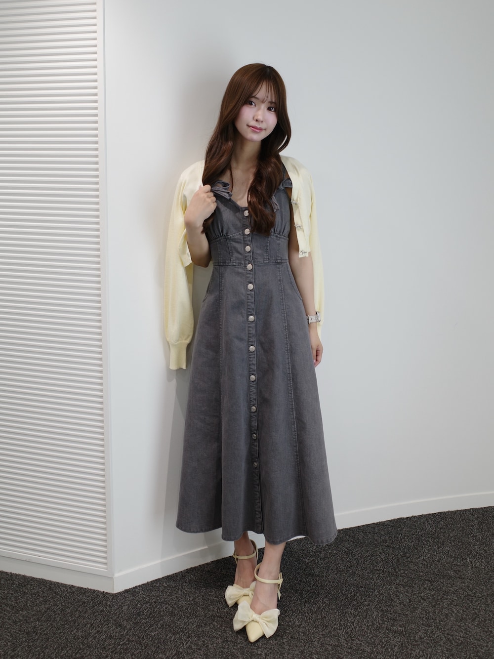 ブラック系のワンピース、イエロー系のパンプス、イエロー系のニット/セーターを着用したレディースの夏コーディネートの1枚目の写真