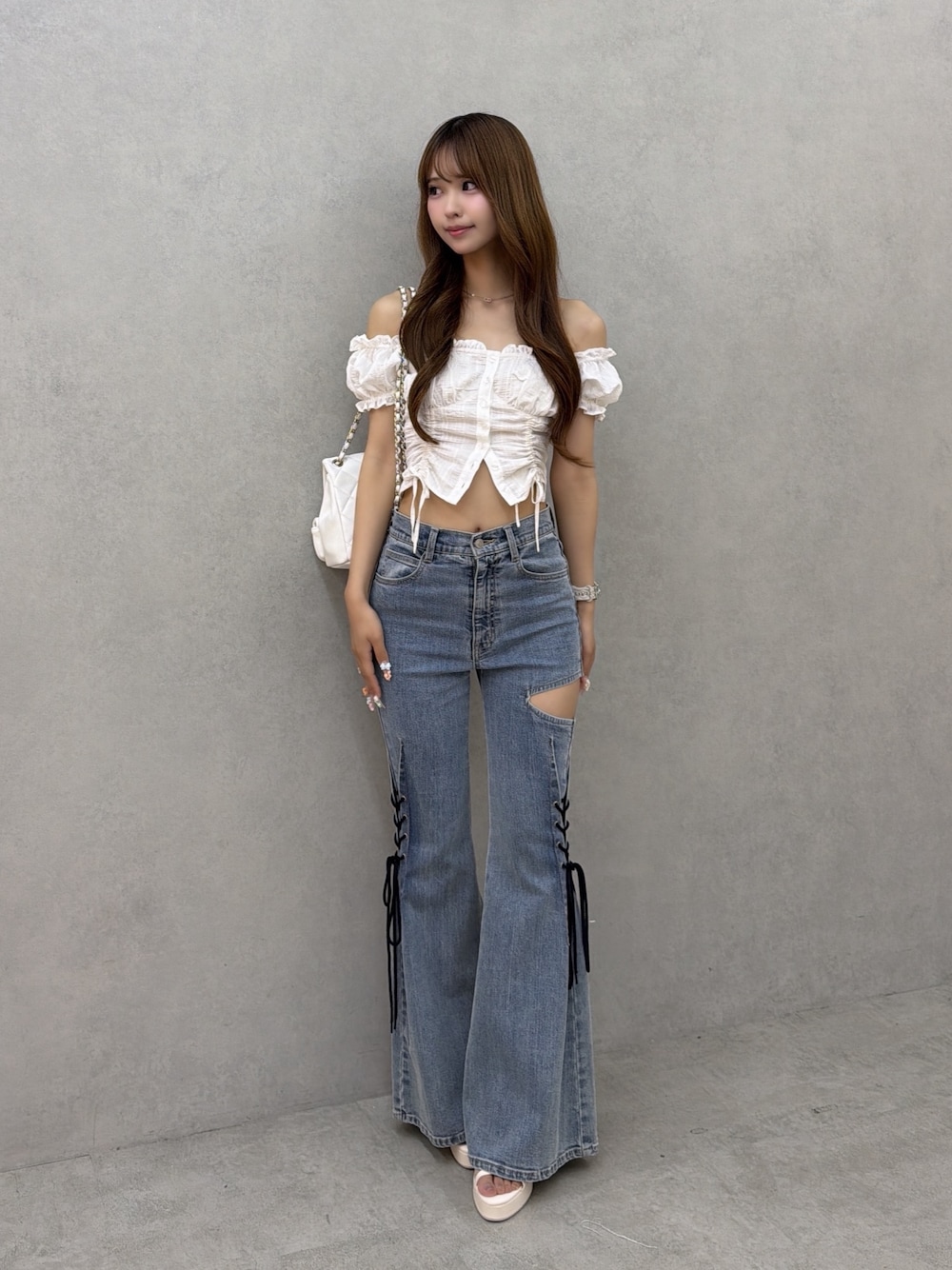 ブルー系のデニムパンツ、ホワイト系のシャツ/ブラウス、ホワイト系のバックパック/リュックを着用したレディースの夏コーディネートの1枚目の写真