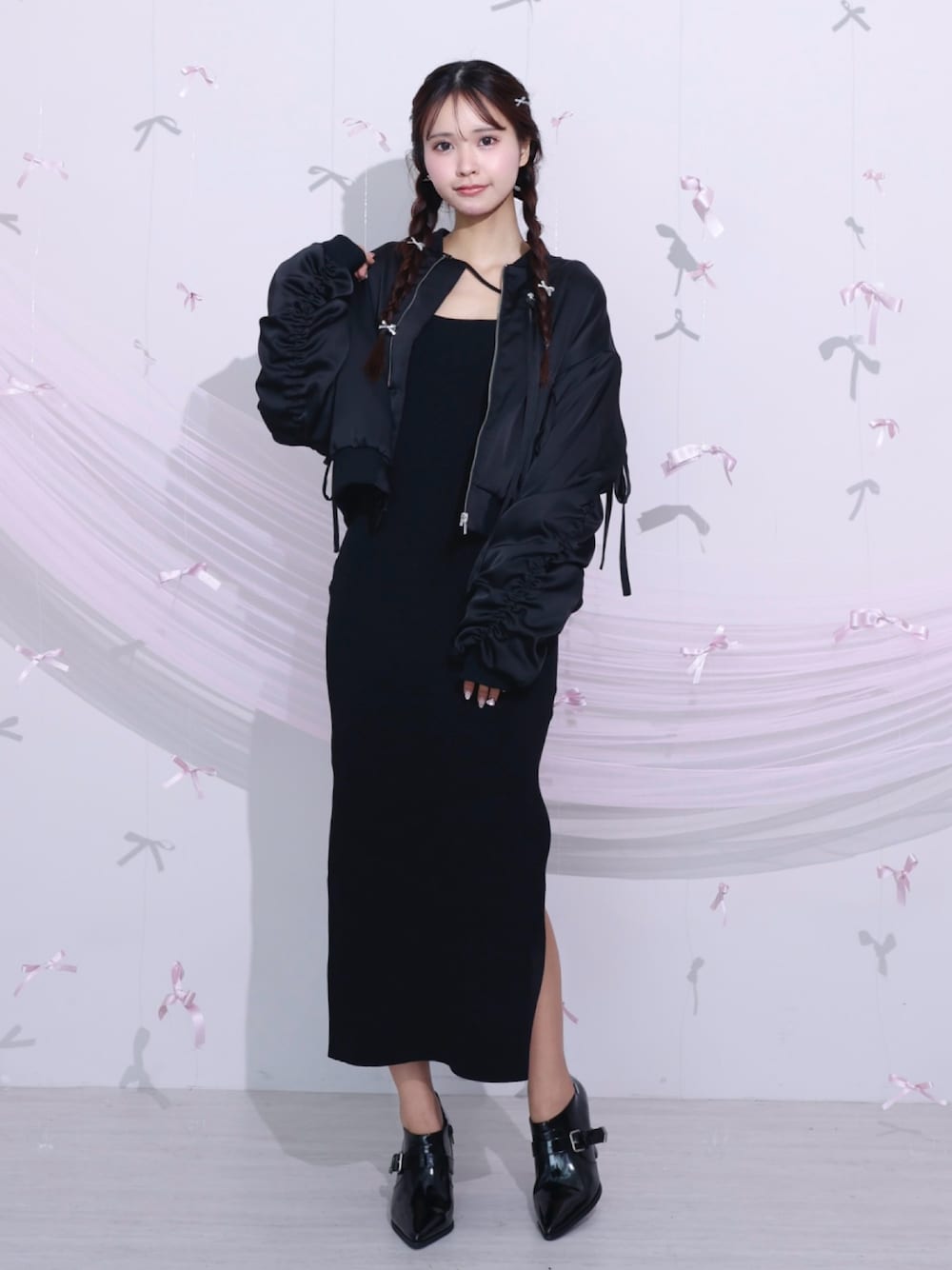 ブラック系のブルゾン、ブラック系のワンピース、ブラック系のブーツを着用したレディースの冬コーディネートの1枚目の写真