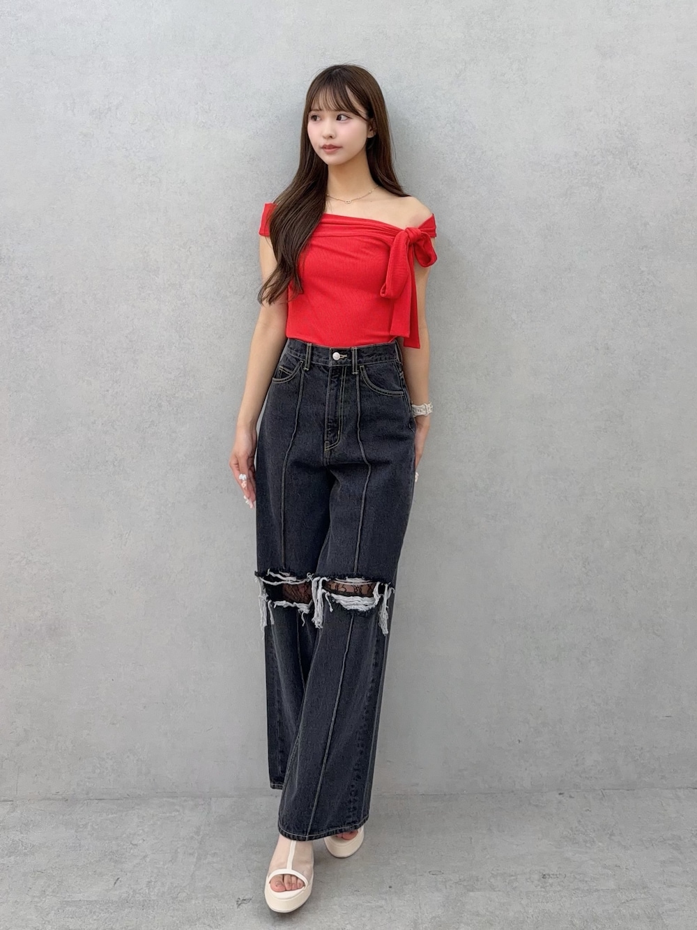 ブラック系のデニムパンツ、レッド系のTシャツ/カットソー、ホワイト系のサンダルを着用したレディースの春コーディネートの1枚目の写真