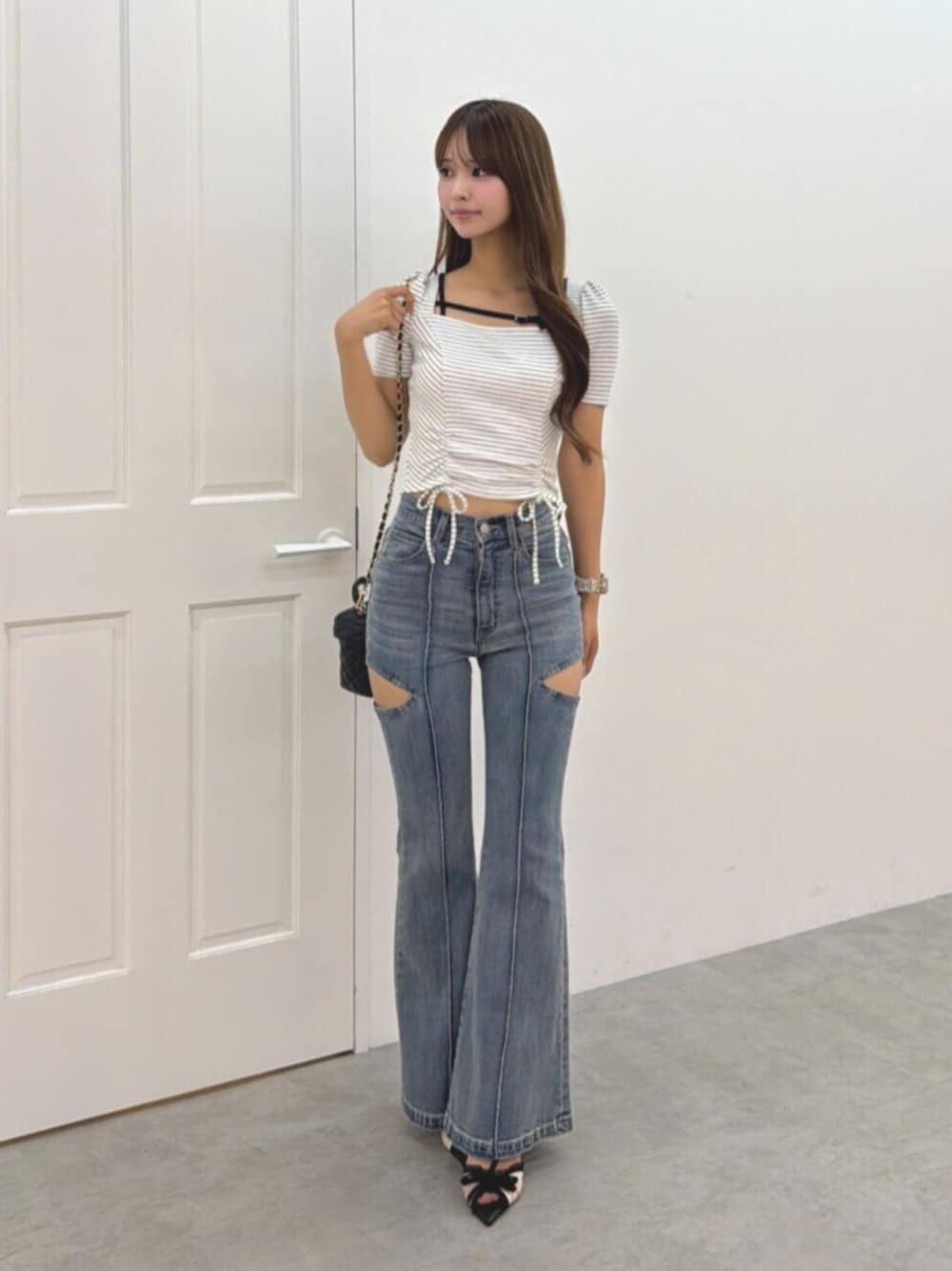 ブルー系のデニムパンツ、ブラック系のハンドバッグ、その他のパンプスを着用したレディースの夏コーディネートの1枚目の写真
