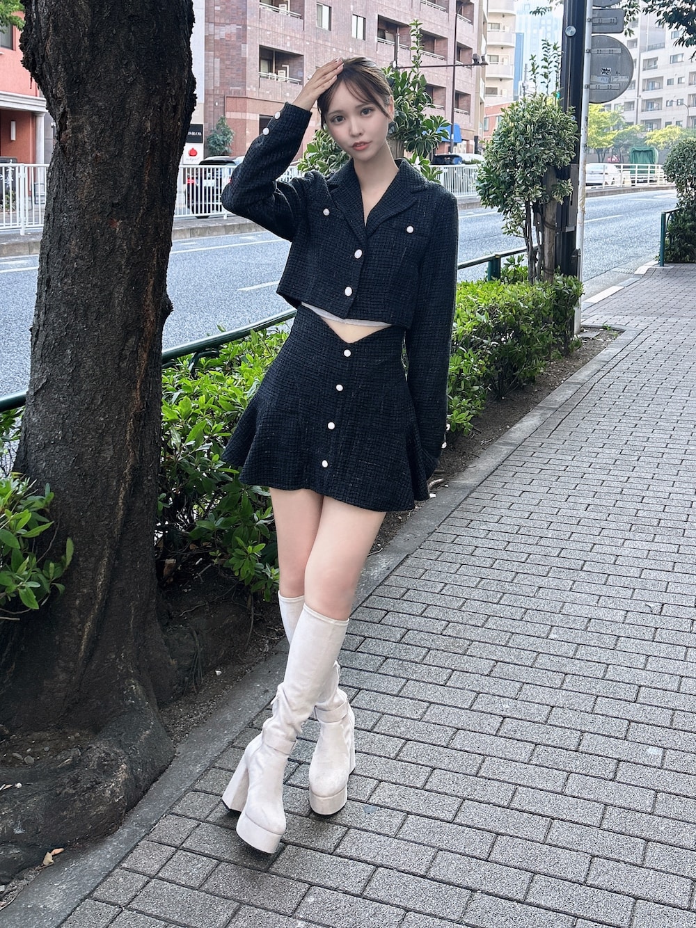 ブラック系のスカート、ブラック系のテーラードジャケット、ホワイト系のブーツを着用したレディースの秋コーディネートの1枚目の写真