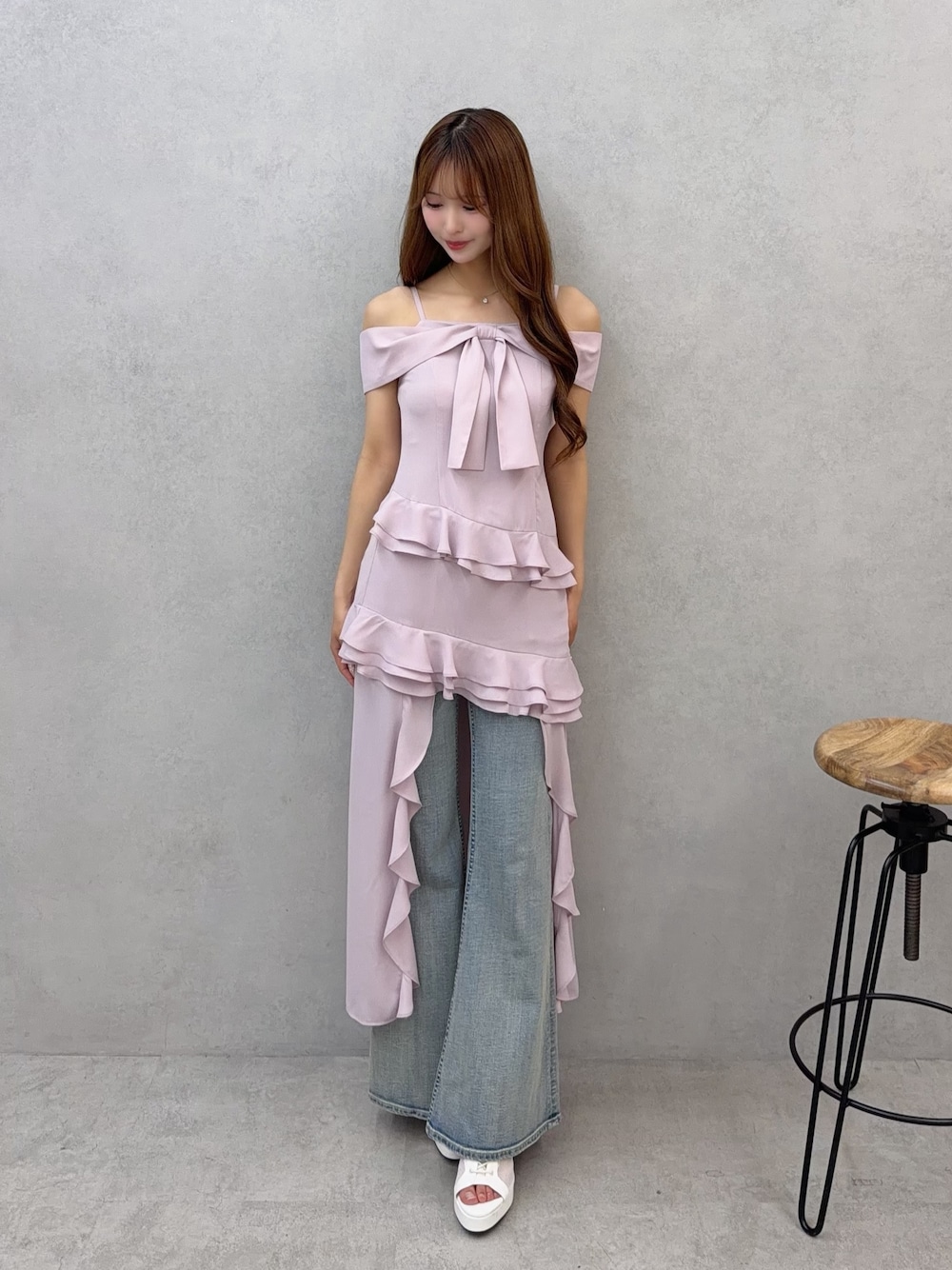ピンク系のワンピース、ブルー系のデニムパンツを着用したレディースの春コーディネートの1枚目の写真
