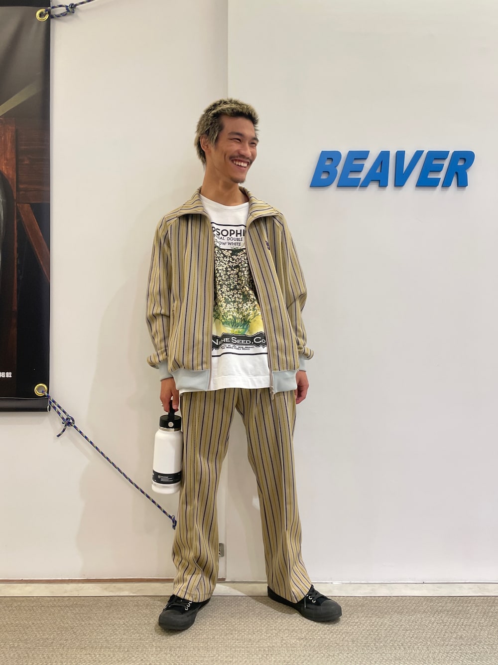 「ジャケット、坊主、休日スタイル、春、リラックススタイル、トラックジャケット、ヒゲ、ニードルス、白Tシャツ、水筒」｜「niche.のniche./ニッチ　Flower Seeds Ｔ-Shirts　フラワーシードＴシャツ（Tシャツ/カットソー、ホワイト系）」を使った、スバルさん（メンズ・165cm）の春コーディネートの1枚目の写真