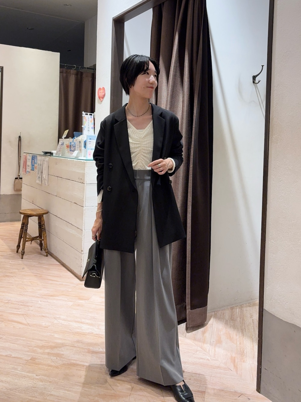 ブラック系のテーラードジャケット、ホワイト系のニット/セーター、グレー系のその他パンツを着用したレディースの秋コーディネートの1枚目の写真