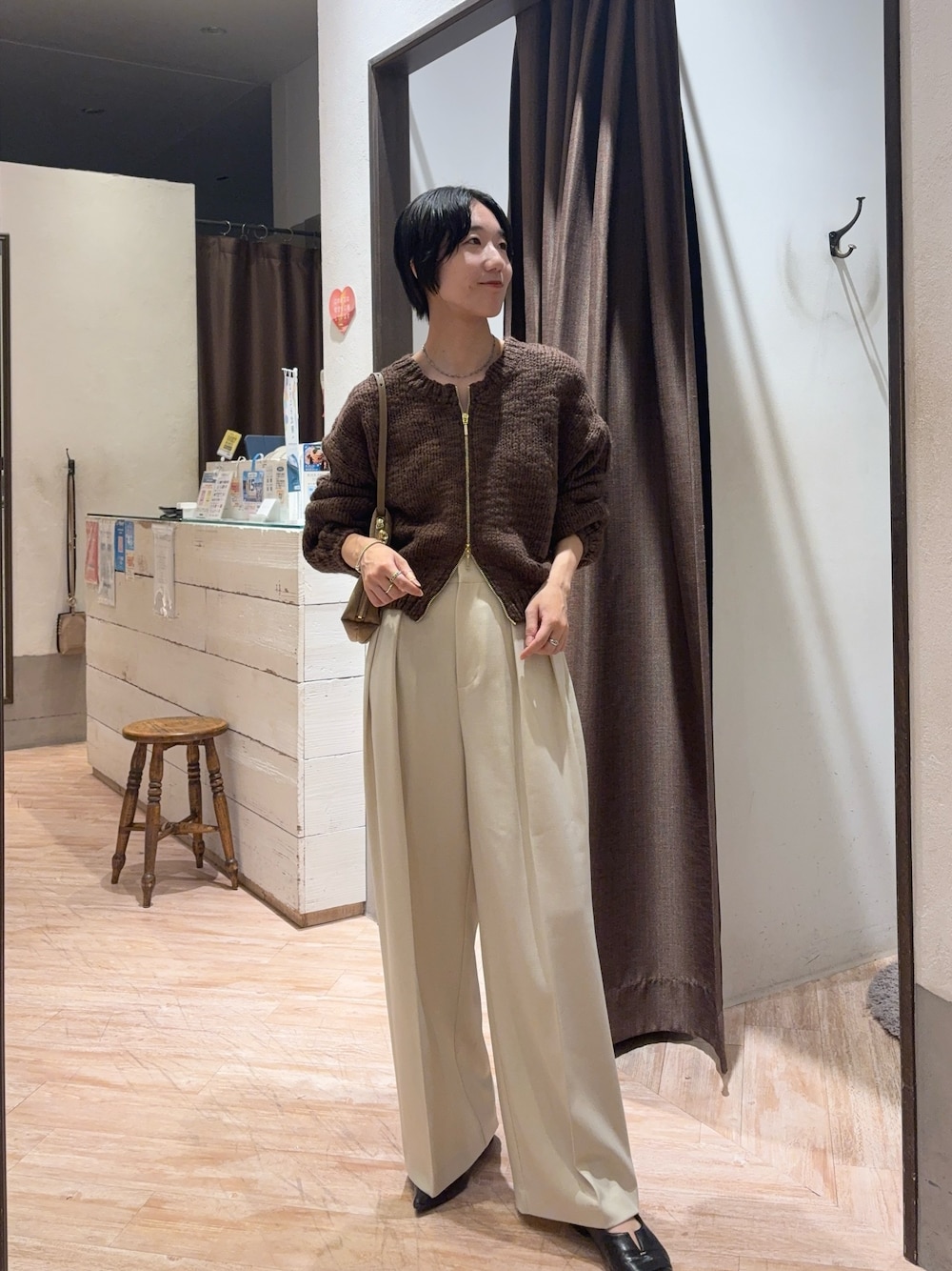 ブラウン系のニット/セーター、ホワイト系のその他パンツを着用したレディースの秋コーディネートの1枚目の写真