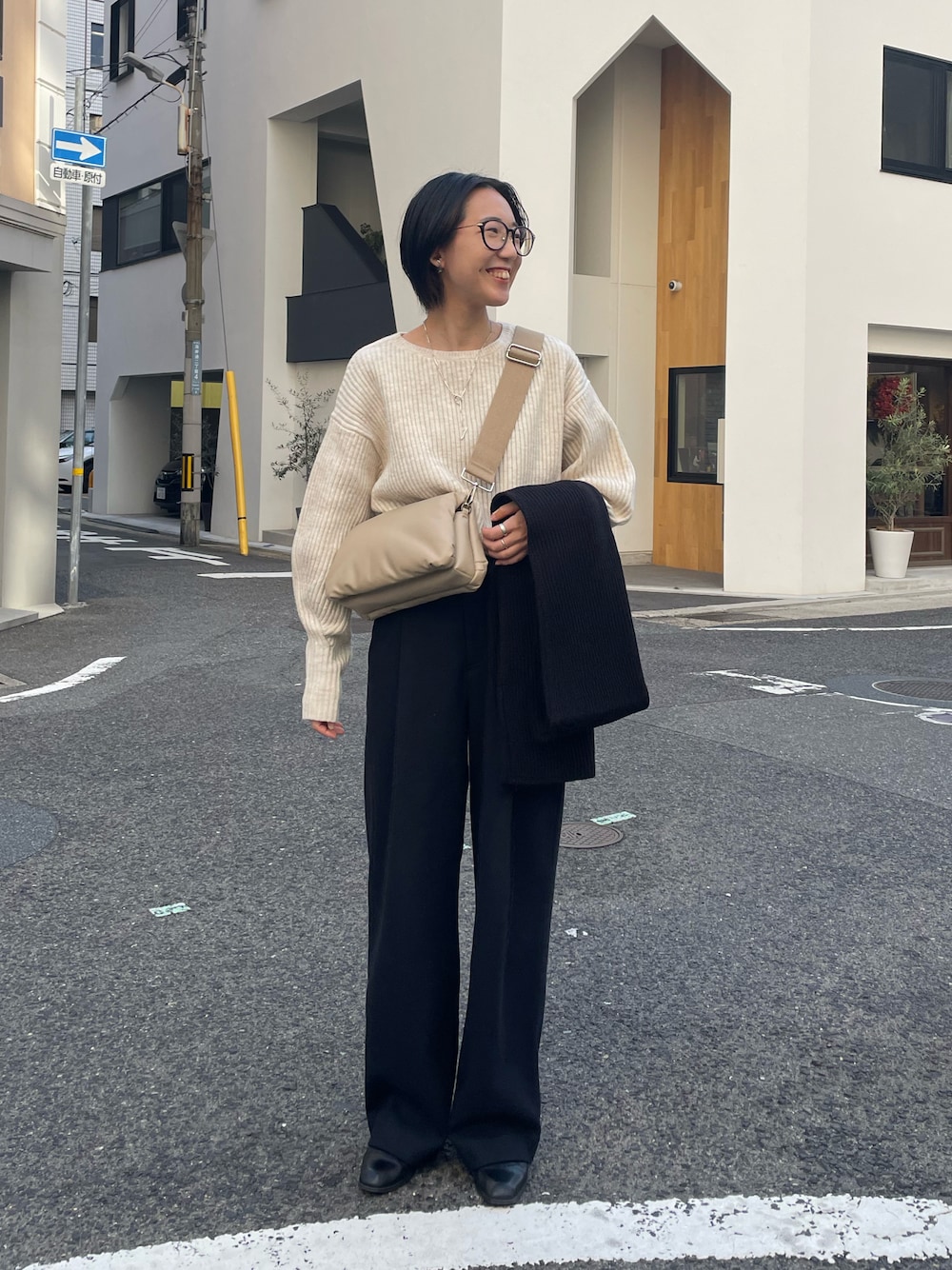 ブラック系のパンツ、ベージュ系のニット/セーター、ブラック系のマスクを着用したレディースの冬コーディネートの1枚目の写真