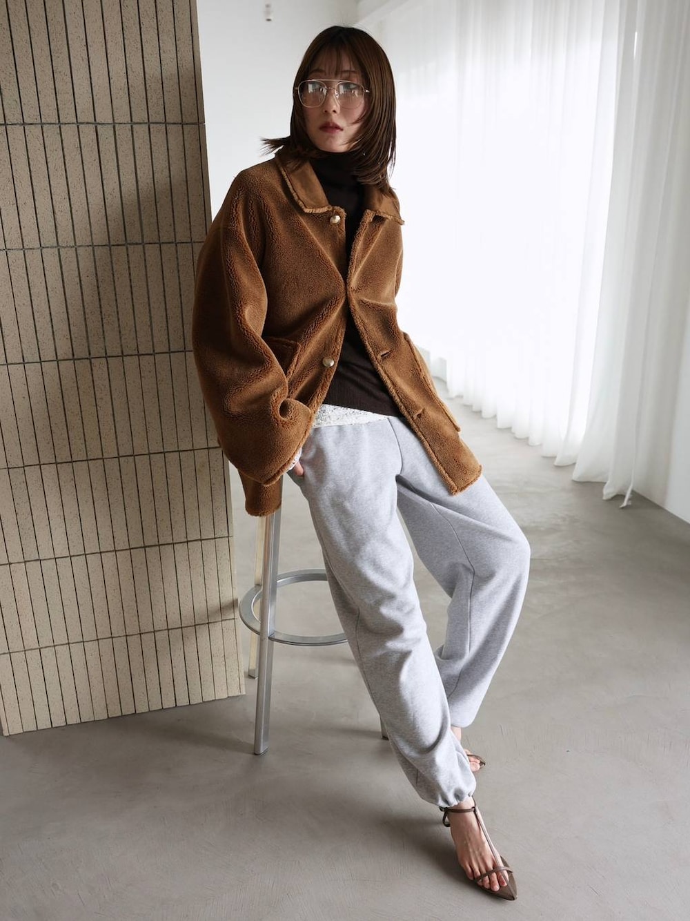 ホワイト系のTシャツ/カットソー、ベージュ系のサンダル、グレー系のスウェットパンツを着用したレディースの秋コーディネートの1枚目の写真