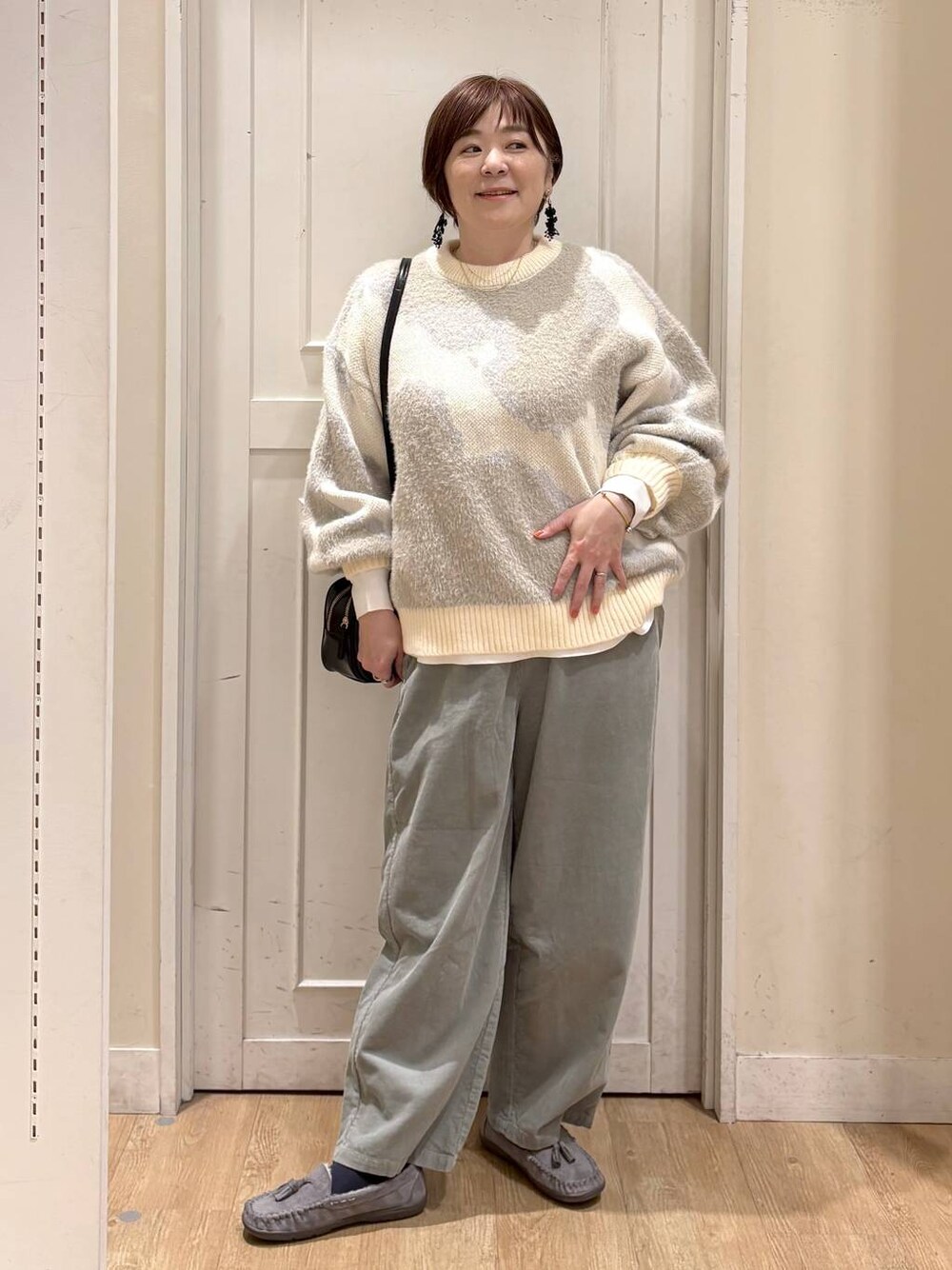 グリーン系のその他パンツ、グレー系のモカシン/デッキシューズ、ブラック系のトートバッグを着用したレディースの秋コーディネートの1枚目の写真